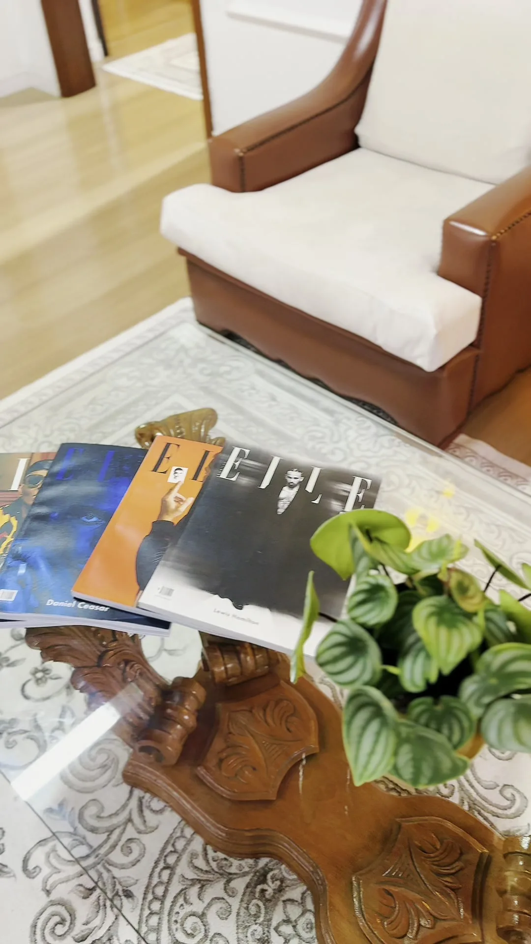 Poltrona de couro e revistas sobre a mesa de centro da sala de espera.